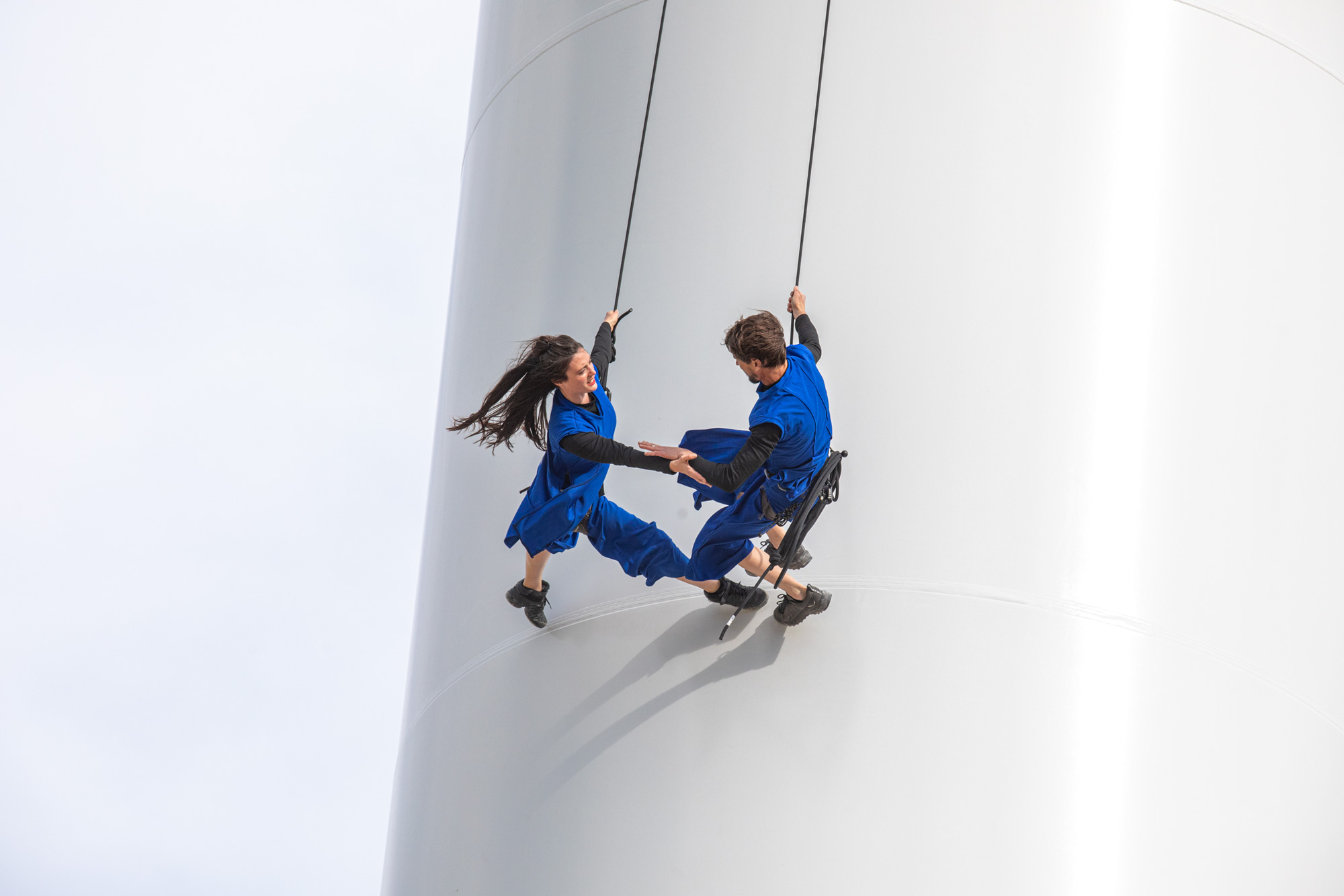 Sur le mât de l’éolienne, les deux danseurs, Lucie et Alex